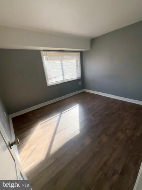 empty room featuring dark hardwood / wood-style flooring