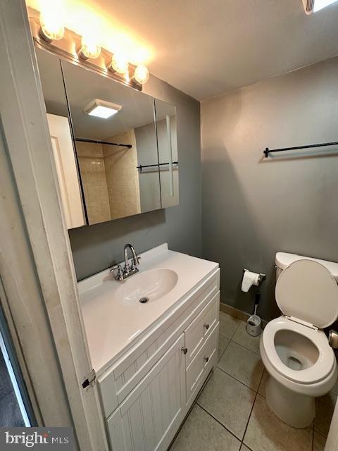 bathroom featuring vanity, tile patterned floors, and toilet