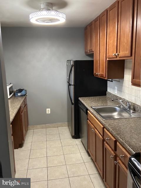 kitchen with sink, light tile patterned floors, backsplash, range with electric stovetop, and stainless steel dishwasher