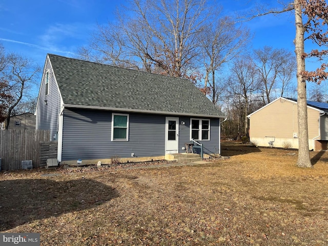 view of front of home with entry steps, a shingled roof, and a front lawn