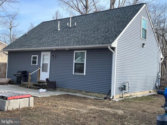 back of house featuring entry steps, a shingled roof, and a patio area