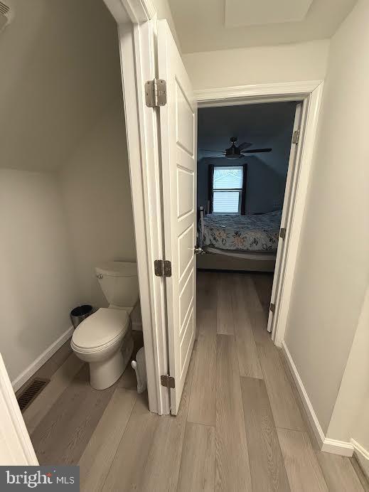 bathroom with visible vents, wood finished floors, toilet, and baseboards