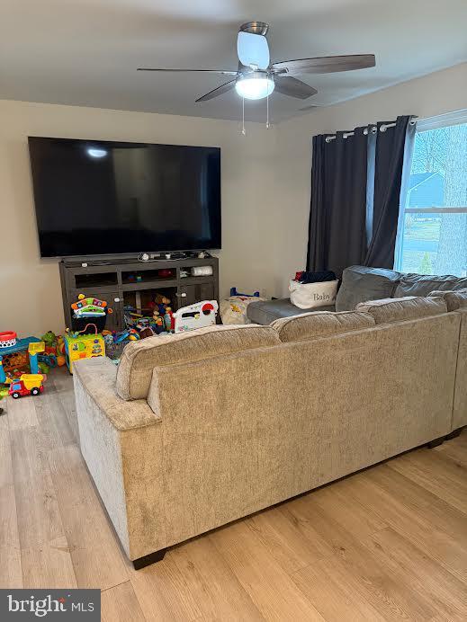 living area with ceiling fan and wood finished floors