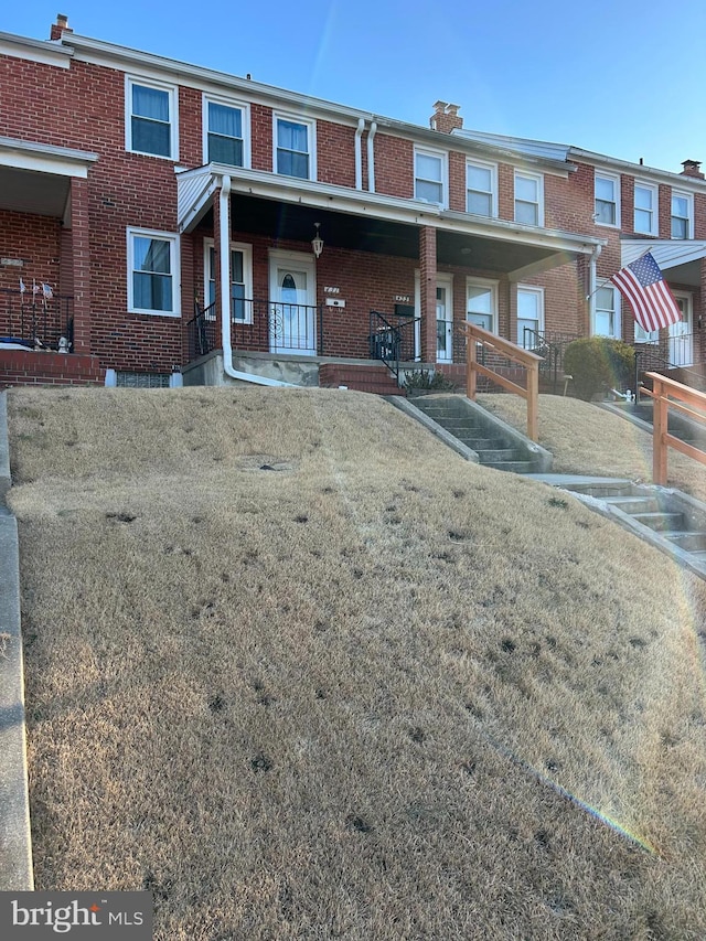 multi unit property featuring a porch and a front yard