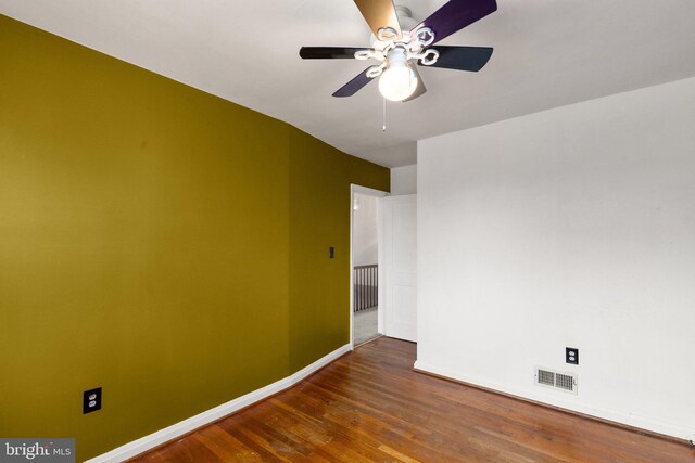 spare room with dark hardwood / wood-style flooring and ceiling fan