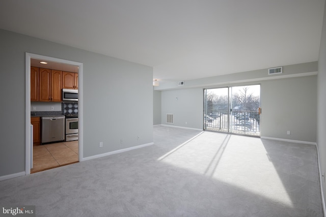 unfurnished living room featuring light carpet