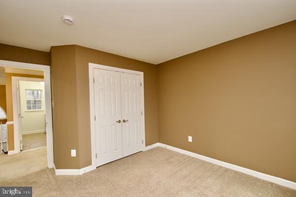 unfurnished bedroom with carpet floors and a closet