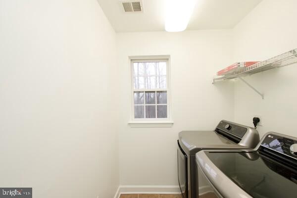 clothes washing area with hardwood / wood-style flooring and separate washer and dryer