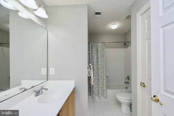 full bathroom featuring shower / bathtub combination with curtain, vanity, tile patterned flooring, and toilet