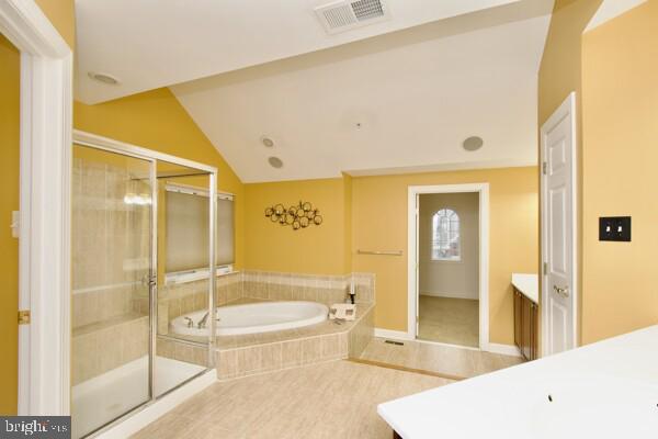 bathroom with vanity, lofted ceiling, and shower with separate bathtub