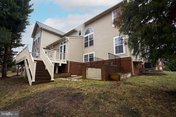 back of property featuring a yard and a deck