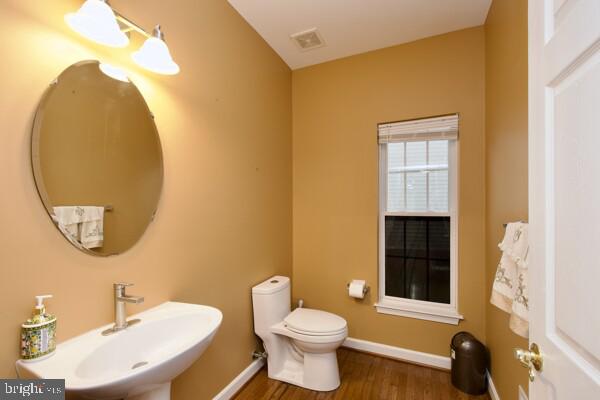 bathroom with sink, hardwood / wood-style flooring, and toilet