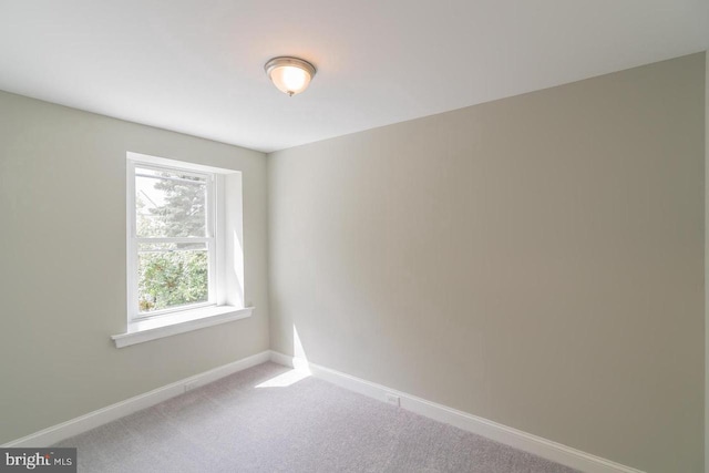 empty room featuring carpet floors and baseboards