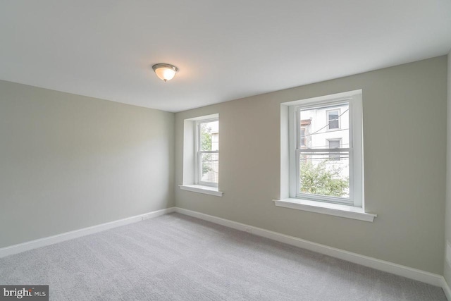 unfurnished room with carpet floors and baseboards