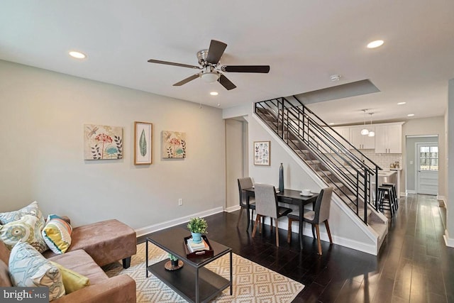 living room with ceiling fan, recessed lighting, dark wood-type flooring, baseboards, and stairs