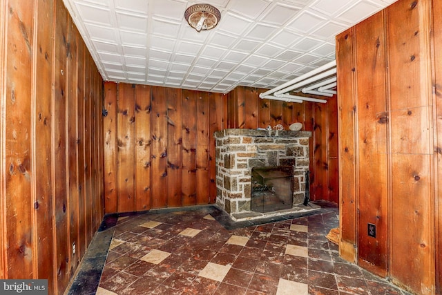 interior space featuring wooden walls and a fireplace