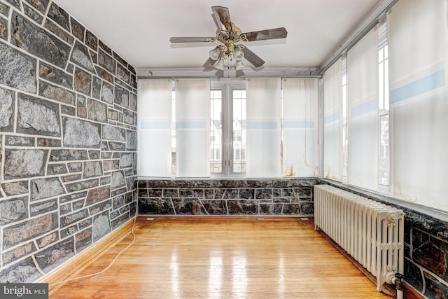 interior space with radiator, plenty of natural light, and ceiling fan