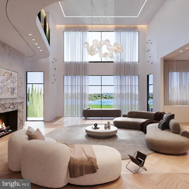 living room featuring a high ceiling, a premium fireplace, and an inviting chandelier