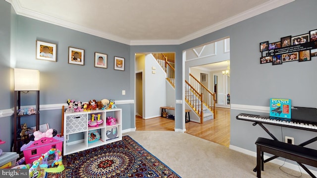 playroom with an inviting chandelier, ornamental molding, and carpet floors