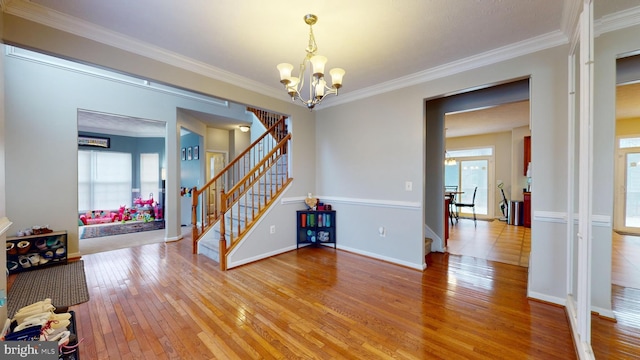 interior space featuring crown molding, a chandelier, and light wood-type flooring