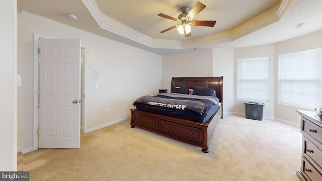 bedroom with a raised ceiling, light carpet, and ceiling fan