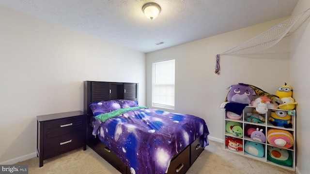 bedroom featuring light carpet and a textured ceiling