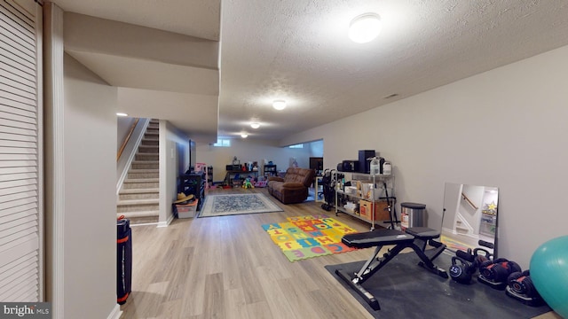 workout room featuring hardwood / wood-style flooring and a textured ceiling