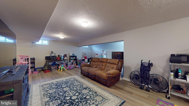 living room featuring wood-type flooring and a textured ceiling