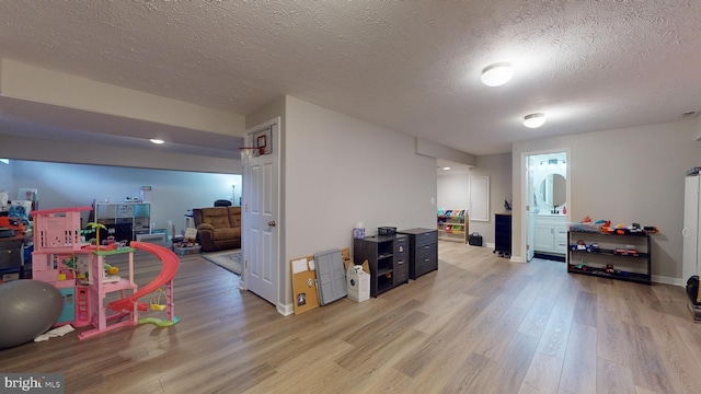 playroom with hardwood / wood-style floors and a textured ceiling