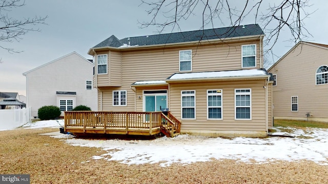 snow covered house with a wooden deck