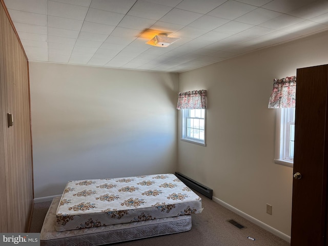 unfurnished bedroom featuring baseboard heating and carpet flooring