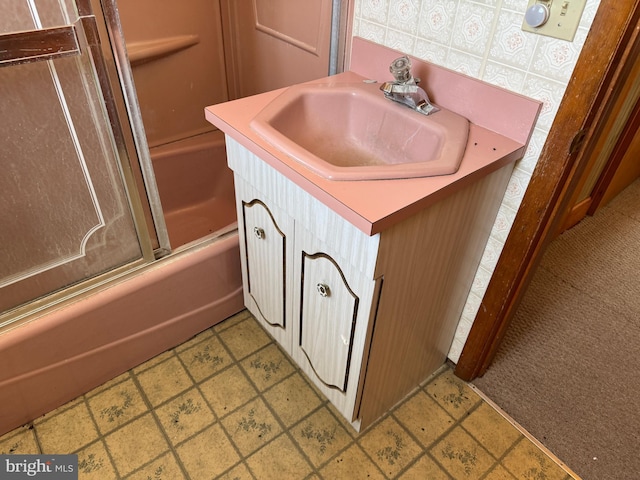 bathroom featuring vanity and bath / shower combo with glass door