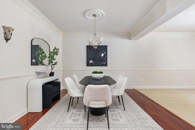 dining room with ornamental molding, wood-type flooring, and a chandelier