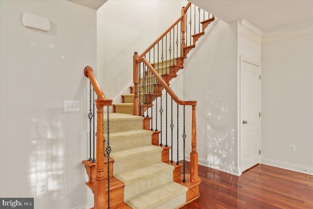 staircase featuring crown molding and hardwood / wood-style flooring