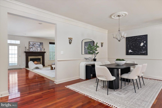 dining area with an inviting chandelier, hardwood / wood-style flooring, and ornamental molding