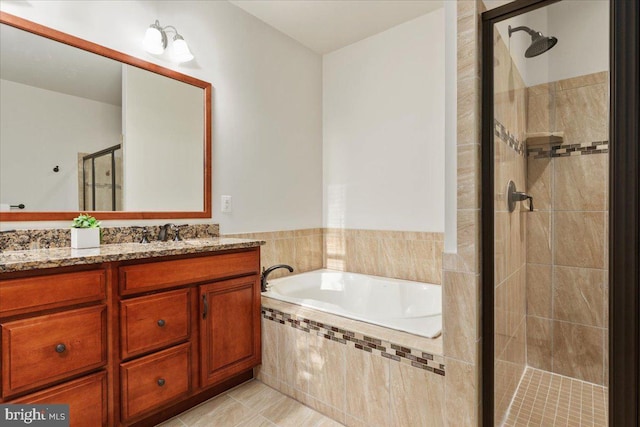 bathroom featuring tile patterned floors, vanity, and shower with separate bathtub