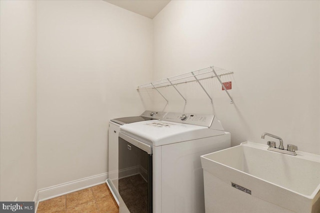 clothes washing area with washing machine and clothes dryer, sink, and light tile patterned floors