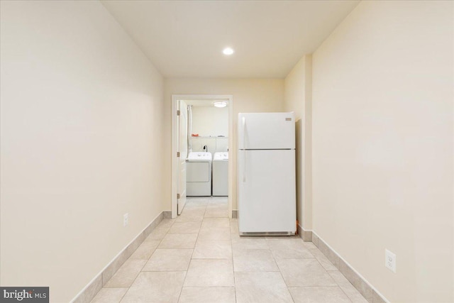 hallway with light tile patterned floors and washer and clothes dryer