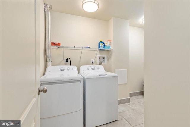 washroom featuring washing machine and dryer and light tile patterned floors