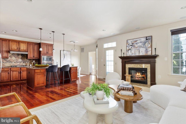 living room with a fireplace and dark wood-type flooring