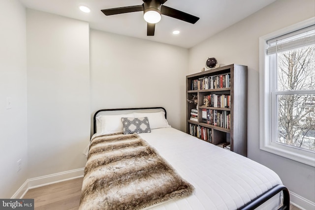 bedroom featuring multiple windows, light wood-type flooring, and ceiling fan