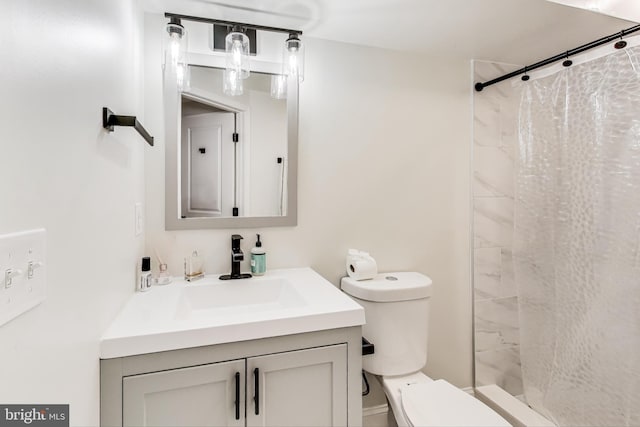 bathroom featuring vanity, toilet, and walk in shower