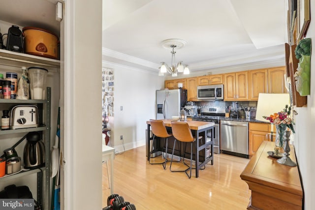 kitchen with decorative light fixtures, tasteful backsplash, a notable chandelier, stainless steel appliances, and light wood-type flooring