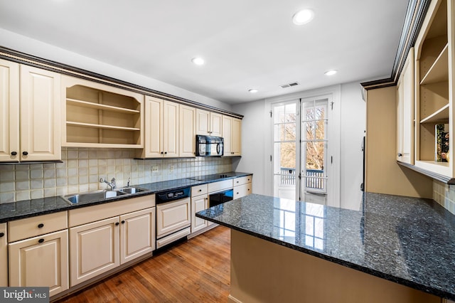 kitchen with sink, backsplash, dark stone counters, black appliances, and dark wood-type flooring