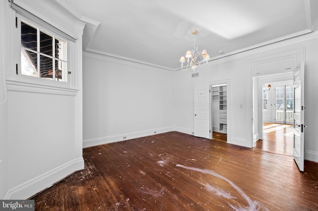 unfurnished dining area with a notable chandelier, ornamental molding, and hardwood / wood-style floors