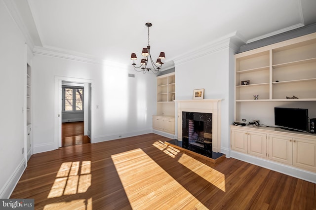 unfurnished living room featuring a fireplace, built in shelves, dark wood-type flooring, and ornamental molding