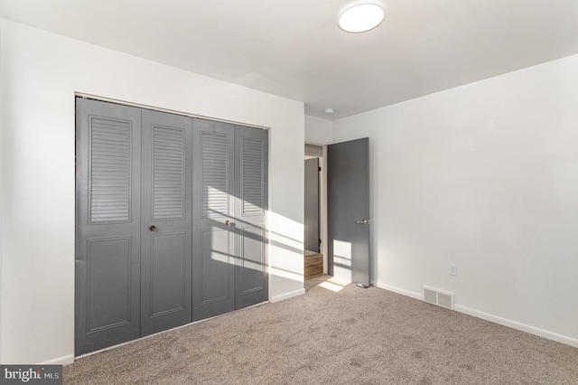 unfurnished bedroom featuring carpet floors and a closet