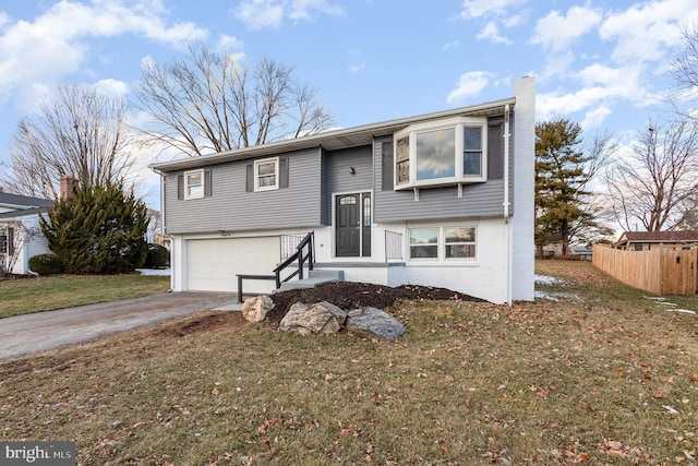 bi-level home with a garage and a front lawn