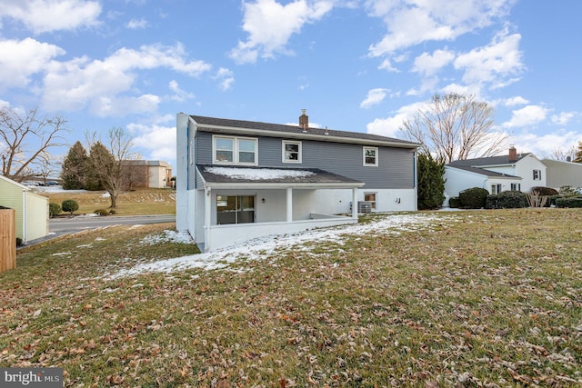 rear view of property featuring a lawn