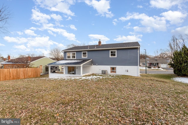 rear view of house with cooling unit, a patio, and a lawn